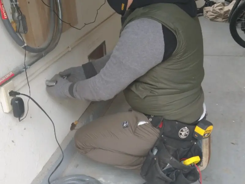 Electrician performing outlet wiring in a Brick garage